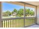 Relaxing view from a screened balcony overlooking a well-maintained lawn and mature trees at 3800 Saxon Dr # 180, New Smyrna Beach, FL 32169