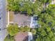 Aerial view of a home with a spacious backyard patio and mature trees offering shade and privacy at 402 N Orange St, New Smyrna Beach, FL 32168