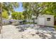 Spacious backyard featuring grill, outdoor seating, shed, mature trees, and white fence at 402 N Orange St, New Smyrna Beach, FL 32168