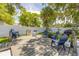 Backyard featuring deck, outdoor seating, grill, mature trees, and white fence at 402 N Orange St, New Smyrna Beach, FL 32168