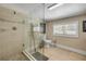 Bright bathroom featuring a glass-enclosed shower with elegant tile work and modern fixtures at 402 N Orange St, New Smyrna Beach, FL 32168