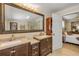 Bathroom featuring dual vanities with granite countertops, a large mirror and a shower at 402 N Orange St, New Smyrna Beach, FL 32168
