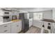 Modern kitchen with white cabinetry, stainless steel appliances, and a cozy dining area at 402 N Orange St, New Smyrna Beach, FL 32168