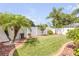 Lush backyard featuring a well-maintained lawn, palm trees, and privacy fencing, enhancing outdoor living at 406 Phillips Creek Ln, New Smyrna Beach, FL 32168