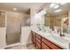 Bathroom featuring a double vanity with marble countertops, a glass shower, and stylish lighting fixtures at 406 Phillips Creek Ln, New Smyrna Beach, FL 32168