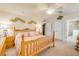 A well-lit bedroom with neutral walls, wooden furniture, a ceiling fan, and two doors, offering a calming space at 406 Phillips Creek Ln, New Smyrna Beach, FL 32168