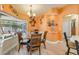 Bright dining room with a glass table set, decorated in a beach theme, with a view of the lanai and backyard at 406 Phillips Creek Ln, New Smyrna Beach, FL 32168