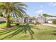 A beautifully landscaped property showcasing lush green grass, palm trees, and a well-maintained home exterior at 406 Phillips Creek Ln, New Smyrna Beach, FL 32168