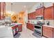 Well-appointed kitchen features warm cabinetry, stainless appliances, and pendant lighting at 406 Phillips Creek Ln, New Smyrna Beach, FL 32168