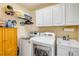 Practical laundry area with washer, dryer, sink, storage cabinet, and shelving at 406 Phillips Creek Ln, New Smyrna Beach, FL 32168