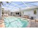 Inviting pool area with lounge chairs, tables, and lush greenery, offering a perfect relaxation space at 406 Phillips Creek Ln, New Smyrna Beach, FL 32168