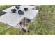 Aerial view of the home featuring the deck with two chairs, AC units on the roof, and trees at 4150 S Atlantic Ave # 111B, New Smyrna Beach, FL 32169
