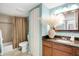 Bathroom featuring tiled shower with curtain, toilet, vanity with sink, and light blue walls at 4150 S Atlantic Ave # 111B, New Smyrna Beach, FL 32169