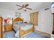 This cozy bedroom features a decorative wood bed frame, ceiling fan, and stylish wall decor at 4150 S Atlantic Ave # 111B, New Smyrna Beach, FL 32169