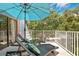 Outdoor deck with an umbrella, two lawn chairs, and wooded views at 4150 S Atlantic Ave # 111B, New Smyrna Beach, FL 32169