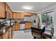 Spacious kitchen with stainless steel appliances, wooden cabinets, and a view of the screened in porch at 4150 S Atlantic Ave # 111B, New Smyrna Beach, FL 32169