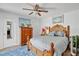 Cozy bedroom featuring a wooden bed frame, ceiling fan, blue rug, and ample natural light at 4150 S Atlantic Ave # 111B, New Smyrna Beach, FL 32169