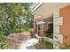Charming patio view with lush landscaping, including flowering plants and an inviting screened-in porch with outdoor dining area at 4150 S Atlantic Ave # 111B, New Smyrna Beach, FL 32169