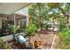 Inviting patio featuring comfortable seating and a beautiful garden view with mature trees and lush foliage all around at 4150 S Atlantic Ave # 111B, New Smyrna Beach, FL 32169