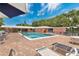 Community pool surrounded by plenty of seating and a brick patio for comfortable enjoyment on a sunny day at 4150 S Atlantic Ave # 111B, New Smyrna Beach, FL 32169