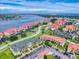 Aerial view shows waterway, community, docks, and residences under a bright blue sky with scattered clouds at 454 Bouchelle Dr # 202, New Smyrna Beach, FL 32169