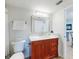 Bathroom featuring a wooden vanity, toilet, mirror and doorway views into the living space at 454 Bouchelle Dr # 202, New Smyrna Beach, FL 32169