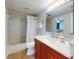 Bathroom featuring a wooden vanity, toilet, bathtub with shower, mirror and doorway views into the bedroom at 454 Bouchelle Dr # 202, New Smyrna Beach, FL 32169