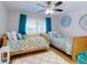 Bright bedroom with twin beds, ceiling fan, and turquoise accents creating a welcoming space at 454 Bouchelle Dr # 202, New Smyrna Beach, FL 32169