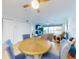 Bright dining area with a wooden table and plush blue chairs, seamlessly flowing into the living space with balcony access at 454 Bouchelle Dr # 202, New Smyrna Beach, FL 32169