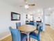 Inviting dining area with round table, comfortable blue chairs, and open view to the kitchen and breakfast bar at 454 Bouchelle Dr # 202, New Smyrna Beach, FL 32169