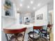 Bright kitchen features white cabinets, stainless appliances and a breakfast bar with stools at 454 Bouchelle Dr # 202, New Smyrna Beach, FL 32169