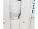 Convenient laundry closet featuring a stacked washer and dryer unit, maximizing space efficiency at 454 Bouchelle Dr # 202, New Smyrna Beach, FL 32169