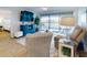 Stylish living room featuring a large TV, comfortable seating, and a scenic view through sliding glass doors to the balcony at 454 Bouchelle Dr # 202, New Smyrna Beach, FL 32169