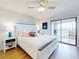 Serene main bedroom with a large bed, stylish side tables, and sliding glass doors leading to a balcony with water views at 454 Bouchelle Dr # 202, New Smyrna Beach, FL 32169