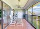 Relaxing screened patio with chairs and footrests boasts serene waterfront views and a ceiling fan at 454 Bouchelle Dr # 202, New Smyrna Beach, FL 32169