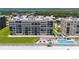 Aerial view of the complex with pool, lush landscaping, and beach access at 4555 S Atlantic Ave # 4310, Port Orange, FL 32127