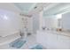 Bathroom with white vanity, soaking tub, enclosed shower, and tile floor at 4555 S Atlantic Ave # 4310, Port Orange, FL 32127