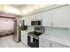 Well-equipped kitchen featuring modern stainless steel appliances, white cabinets, and a breakfast bar overlooking the dining area at 4555 S Atlantic Ave # 4310, Port Orange, FL 32127