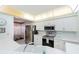 Well-lit kitchen features white cabinets, stainless steel appliances, and a breakfast bar overlooking the dining area at 4555 S Atlantic Ave # 4310, Port Orange, FL 32127