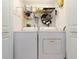 Bright laundry room with white washer and dryer, storage shelf, and decorative wreath detail at 4555 S Atlantic Ave # 4310, Port Orange, FL 32127