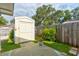 Backyard shed surrounded by grass, a wooden fence, and garden at 5146 Pineland Ave, Port Orange, FL 32127