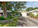 Well-maintained single-story home with a green roof, lovely landscaping, and a paved driveway at 5146 Pineland Ave, Port Orange, FL 32127