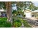 Inviting home with lush front lawn, garden beds, and two blue chairs on the porch at 5146 Pineland Ave, Port Orange, FL 32127