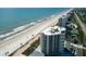 Stunning aerial view of a beachfront condo building, showcasing its proximity to the ocean and surrounding community at 5207 S Atlantic Ave # 224, New Smyrna Beach, FL 32169