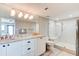 Bathroom featuring a dual sink vanity, large mirror, and a modern walk-in shower with a bench at 5207 S Atlantic Ave # 224, New Smyrna Beach, FL 32169