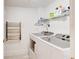 Functional laundry room with modern washer and dryer, and storage shelf for supplies at 5207 S Atlantic Ave # 224, New Smyrna Beach, FL 32169