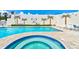 Community pool area with a hot tub and lounge chairs, surrounded by a decorative wall with murals at 5207 S Atlantic Ave # 224, New Smyrna Beach, FL 32169