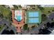 Overhead shot of a community pool, tennis courts, shuffleboard court, and parking area at 5300 S Atlantic Ave # 5-502, New Smyrna Beach, FL 32169