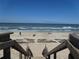 Beach access stairs leading to a sandy beach with ocean views, inviting relaxation by the water at 5300 S Atlantic Ave # 5-502, New Smyrna Beach, FL 32169