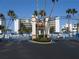 Gated entrance leading to a beachfront condo building with palm trees and a well-manicured landscape at 5300 S Atlantic Ave # 5-502, New Smyrna Beach, FL 32169
